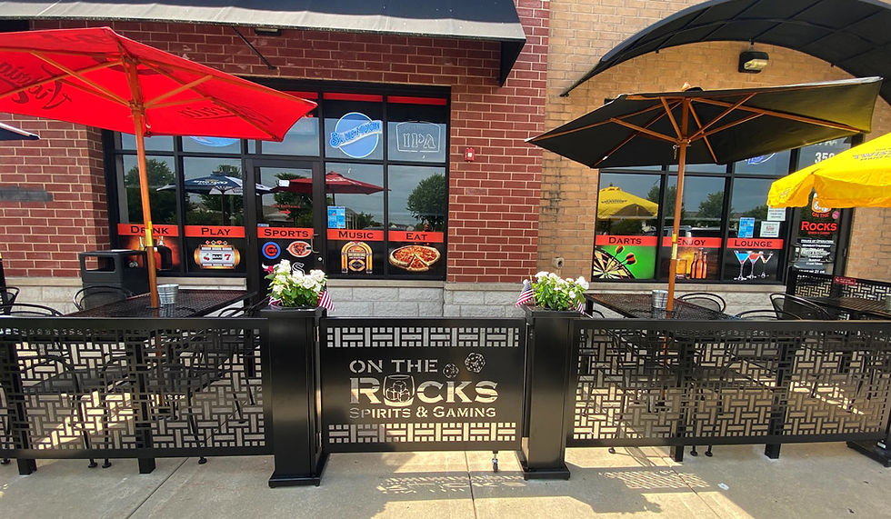 Front view of restaurant patio with planters and a gate