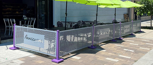 Al fresco dining area with gray and purple barriers and bright green umbrellas