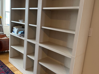 a stack of books sits on top of a bookshelf