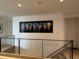 a staircase with a glass railing and a painting on the wall above it