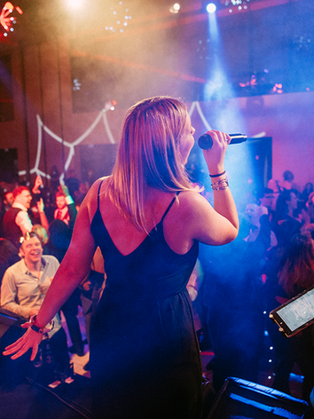 Under the Covers soul and pop party band leading a packed crowd at a festive live event.