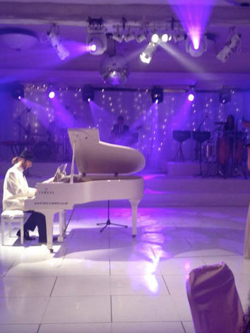 AURA Showband pianist performing on a white grand piano at luxury UK wedding drinks reception.