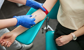 Professional female phlebotomist performing a venipuncture procedure.jpg