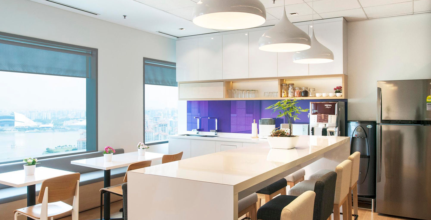 Sleek office pantry with a well-equipped kitchen and bar, perfect for employee gatherings