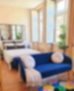 Bright studio apartment with blue couch and bed