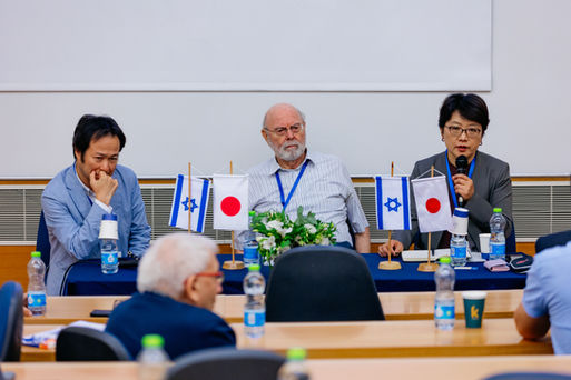 Panelists at a conference on Japan and Israel, with flags from both nations.