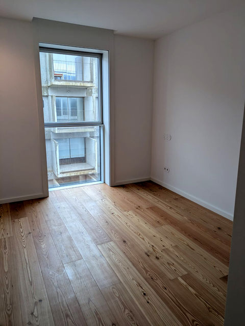 Bright apartment room with hardwood floors and large window