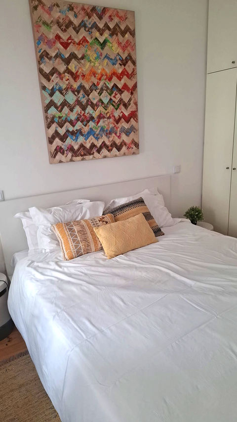 Colorful bedroom with white bedding and patterned pillows