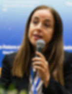 Woman in black blazer speaking into a microphone