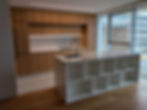 Modern kitchen island with white shelves and wooden cabinets