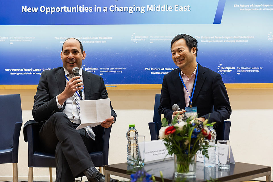 Two men speaking at the Israel-Japan-Gulf Conference