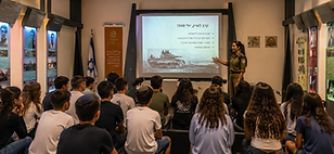 A soldier gives instruction to a group of students at a visitors center