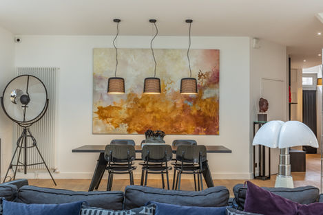 Espace de vie lumineux mêlant mobilier contemporain, tableau grand format et matériaux naturels.