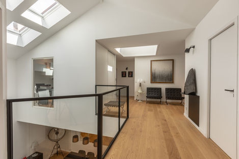 Palier épuré, baigné de lumière grâce à un puits de jour, reliant les chambres à l’étage.