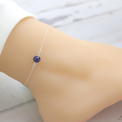 Elevate your style with the Blue Sapphire Sterling Silver Anklet from Shokoro's dainty jewelry collection. This exquisite birthstone anklet is more than just a piece of jewelry; it’s a delicate expression of elegance and personal significance. Crafted with meticulous attention to detail, it effortlessly complements any outfit, making it an essential addition to your jewelry collection.  The anklet features a 1.5" adjustable extender chain, allowing you to customize the fit to your liking. Choose from various chain styles, including Rolo, Cable, and Paper Clip, and embrace the art of layering or wear it alone for a minimalist statement. Each piece is designed to enhance your natural beauty while providing a touch of sophistication.  Sapphire, the birthstone for September, is renowned not just for its stunning blue hue but also for its powerful properties. It is believed to enhance charisma, attract business luck, and protect its owner from negativity. Wearing this anklet can serve as a reminder to stay focused on your goals and aspirations, fostering a sense of tranquility and confidence.