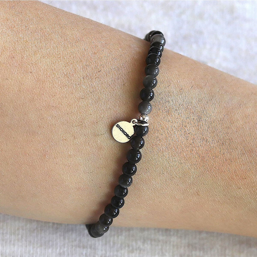Wearing a dainty 4mm Black Obsidian bracelet. Minimalist black crystal jewelry for protection and quiet luxury styling.
