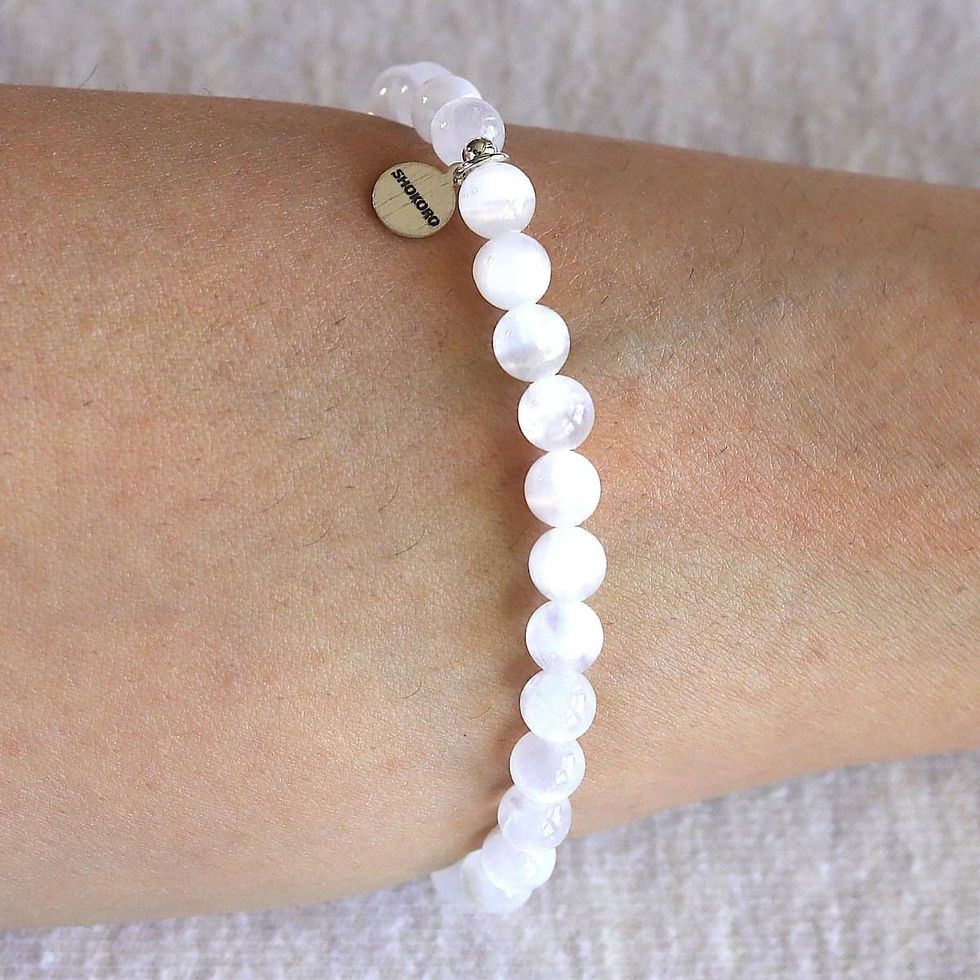 Wearing a 6mm Selenite bracelet for healing. Minimalist white crystal jewelry for quiet luxury styling. Shokoro.