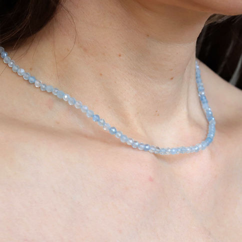 Wearing a dainty 3mm Aquamarine necklace. Minimalist light blue crystal jewelry for calm and quiet luxury styling.