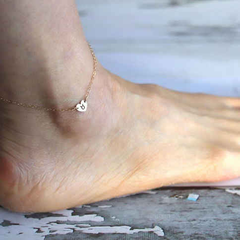 Wearing a Taurus zodiac heart anklet with dainty 14k gold filled chain, layering symbol for summer vacation.