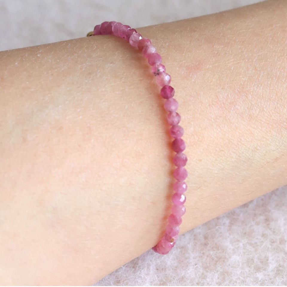 Close-up, wearing a Pink Tourmaline beaded bracelet on bare skin, handcrafted quality and minimalist style for self-love.
