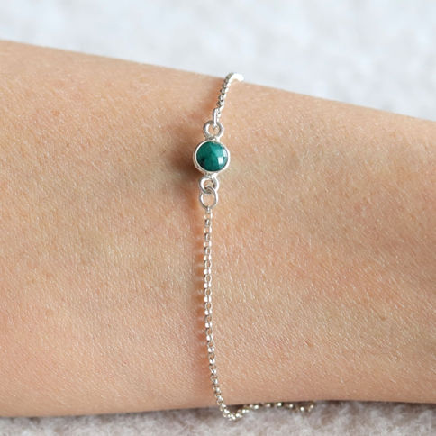 Close-up of delicate Emerald crystal bracelet. Sterling silver dainty jewelry handcrafted in Toronto, Ontario, Canada.
