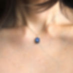 Close-up, blue labradorite pendant on a dainty silver chain necklace. Rare minimalist crystal jewelry handmade in Canada.