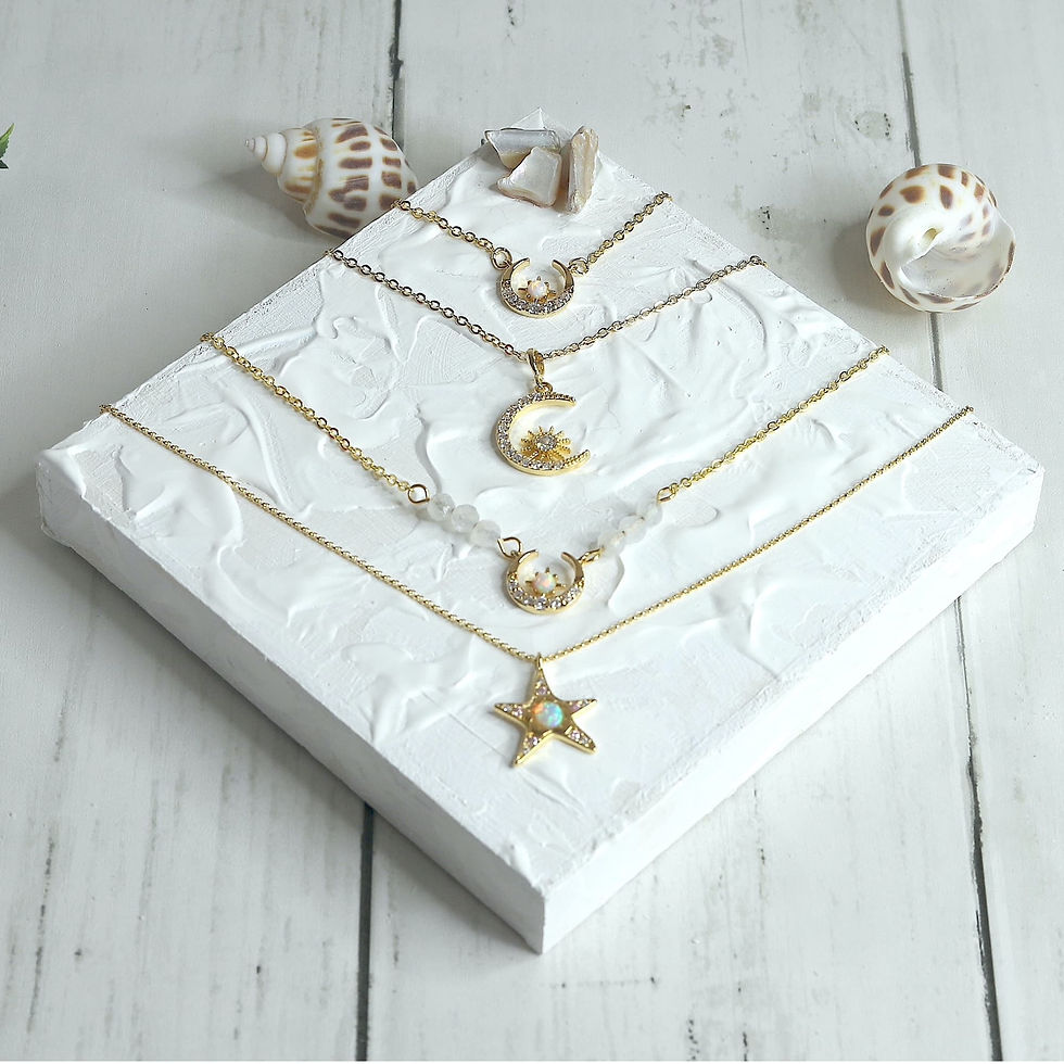 Gold necklaces with crescent and star pendants displayed on white textured canvas, Elegant and beautiful cosmic necklaces