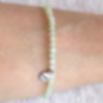 Wearing a dainty 4mm 5A Prehnite bracelet. Minimalist green crystal jewelry for peace and quiet luxury styling.