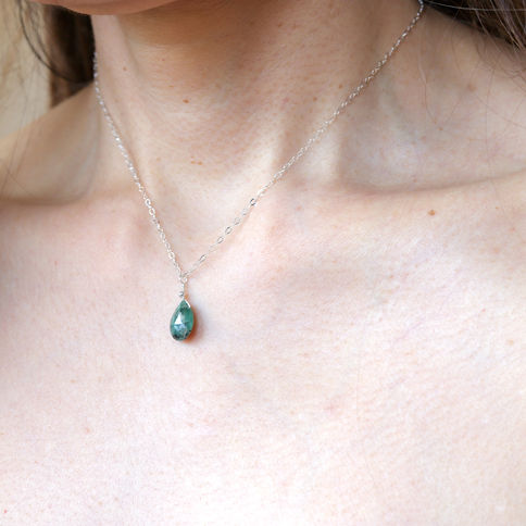 Woman is wearing a genuine emerald necklace with a delicate chain, Elegant and Natural look with healing benefits