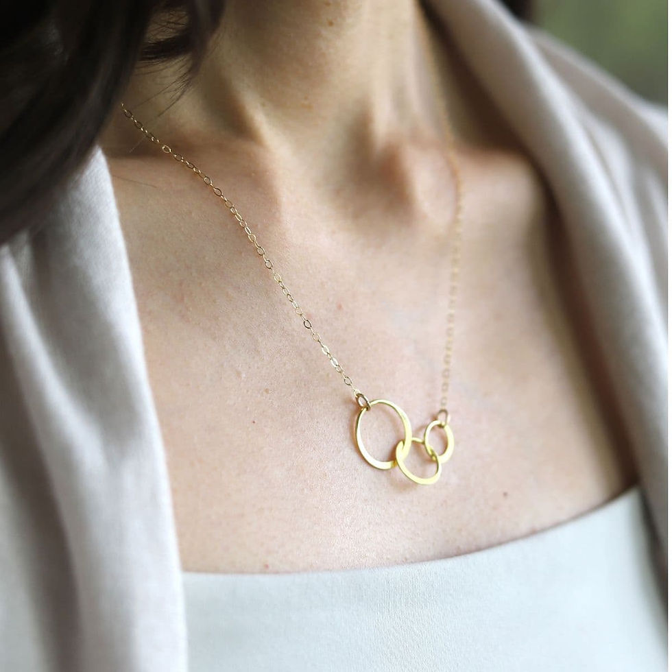 Close-up wearing a high quality interlocking three circle gold necklace with dainty chain, showcasing warm glow of minimalist loon in simplicity, handcrafted by Shokoro in Toronto, Canada.