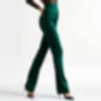 Woman posing in green high-waisted pants and a black lace top against a plain white background, wearing black heels.