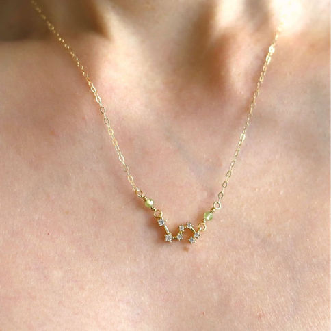 Model wearing gold-filled Leo zodiac constellation necklace with custom birthstones. Quiet Luxury minimalist style.