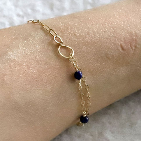 Model wearing a half paperclip lapis lazuli mixed chain station bracelet in gold-filled, artisan layered jewelry gift for her