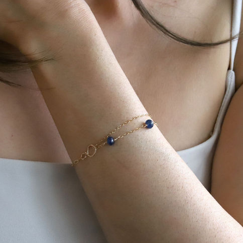 Lifestyle view of a natural sapphire bracelet worn with a modern outfit to showcase a quiet luxury jewelry style.