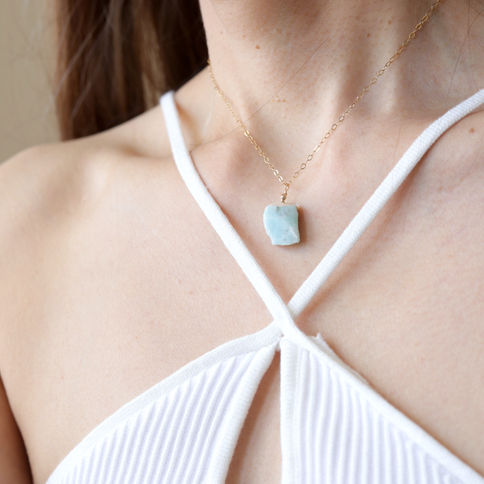 Woman with halter top is wearing a Raw blue larimar necklace. Elegant and feminine jewelry.
