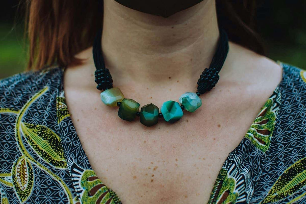 Close-up of a woman's chest wearing a necklace with large green stones. featuring the complete styling guide look with Shokoro Handmade, artisan Malachite jewelry