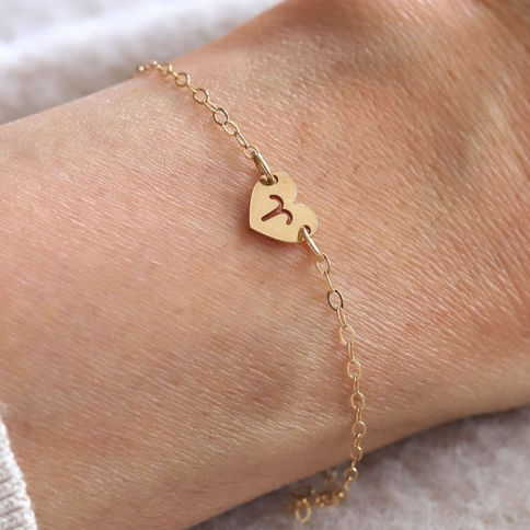 Aries Fire sign heart bracelet on wrist. High-quality 14k gold filled dainty zodiac jewelry by Shokoro Toronto.