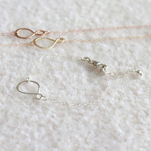 Delicate infinity bracelet with .925 sterling silver chain, showing sophisticated minimalist design for everyday wear.