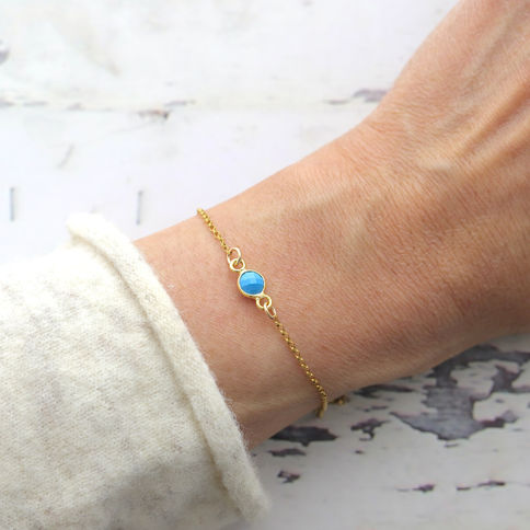 Close-up worn a turquoise gold dainty bracelet, delicate thin chain choice, bezel setting layering jewelry