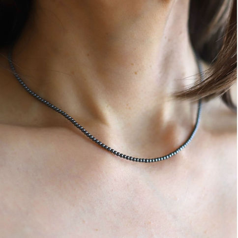 Dainty 2mm metallic grey Hematite gemstone necklace layered on collarbone, handcrafted for everyday luxury style from Shokoro