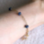 Side view of a 14k gold filled sapphire bracelet on a wrist demonstrating the delicate drape and high-quality shine.