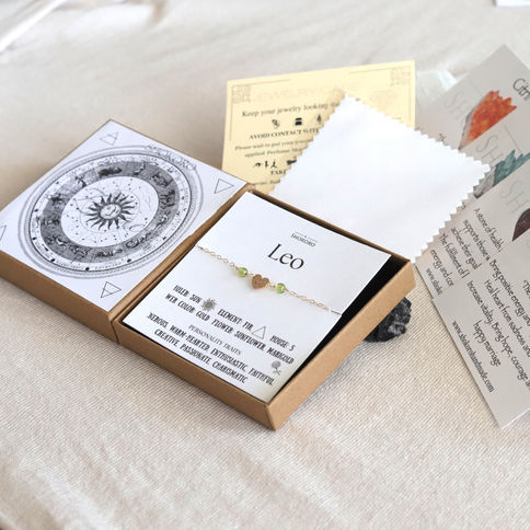Open box with a Leo-themed bracelet with birthtones on white card. Astrological chart and care instruction. Artisan-made.
