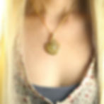 Close-up wearing a gold ammonite necklace, showcasing large statement for layering jewlery.