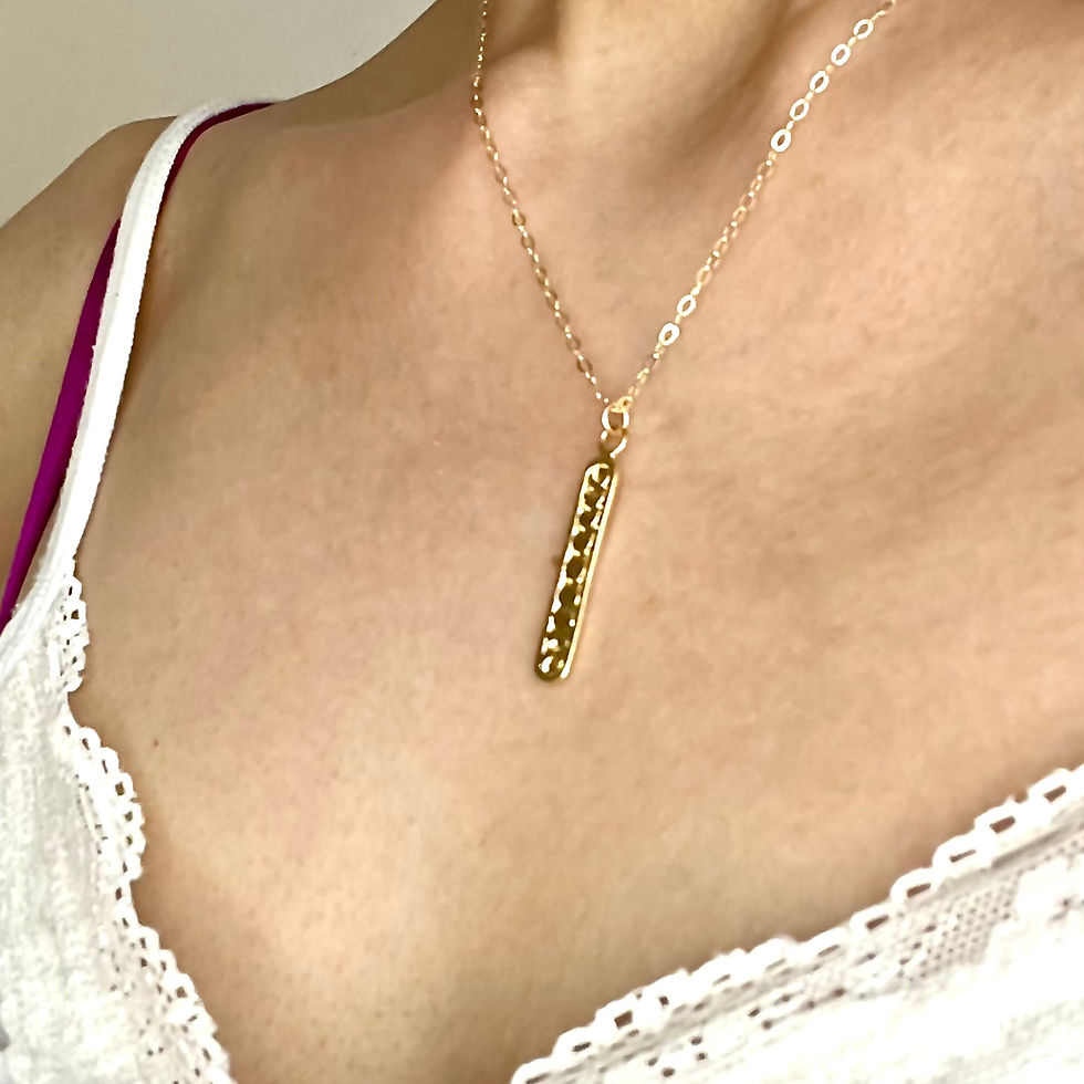Gold moon phases pendant with delicate chain on a person wearing a white top. Elegant and feminine jewelry. Heavenly charm.