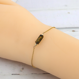 Experience the allure of our AAA Grade Natural Tiger Eye Bracelet, a piece that embodies timeless elegance and sophistication. Available in your choice of 14k gold filled or sterling silver, this dainty bracelet is designed to effortlessly complement any outfit—making it the perfect accessory for both special occasions and everyday wear.  The simplicity of this bracelet speaks volumes, enhancing your style with a touch of refined beauty. Imagine slipping it on as you prepare for a night out or wearing it casually during your day-to-day activities; its versatile design ensures you always look polished and put together.  But this bracelet is more than just a beautiful accessory. The Tiger Eye gemstone, with its mesmerizing golden-brown hue, is known for its profound meaning and powerful healing properties. This captivating stone ignites inner strength, helping you stand tall in the face of challenges. It acts as a grounding force, relieving stress and restoring vitality to your spirit. Picture the warm, earthy energy of Tiger Eye wrapping around you like a protective shield, empowering you to face life's obstacles with unwavering courage.  Embrace the transformative power of Tiger Eye and unlock your true potential, finding balance and harmony in your daily life. Whether you're treating yourself or searching for the perfect gift, this Dainty Crystal Bracelet—crafted with care and adorned with a delicate chain—offers a touch of luxury that is beautifully ready for gifting.