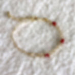 Artisan ruby gemstone bracelet arranged in a circle showing the unique texture of faceted rubies and gold links.