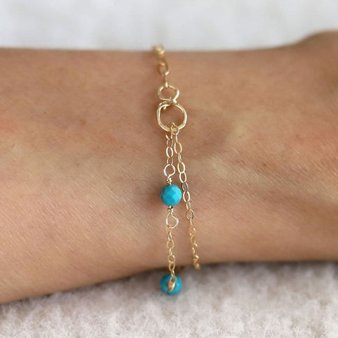 Model wearing a half paperclip turquoise mixed chain bracelet in 14k gold filled, handcrafted birthstone gift for women.