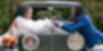 a Black couple smiling over a vintage car in their wedding attire as taken by a Charlottesville va wedding photographer