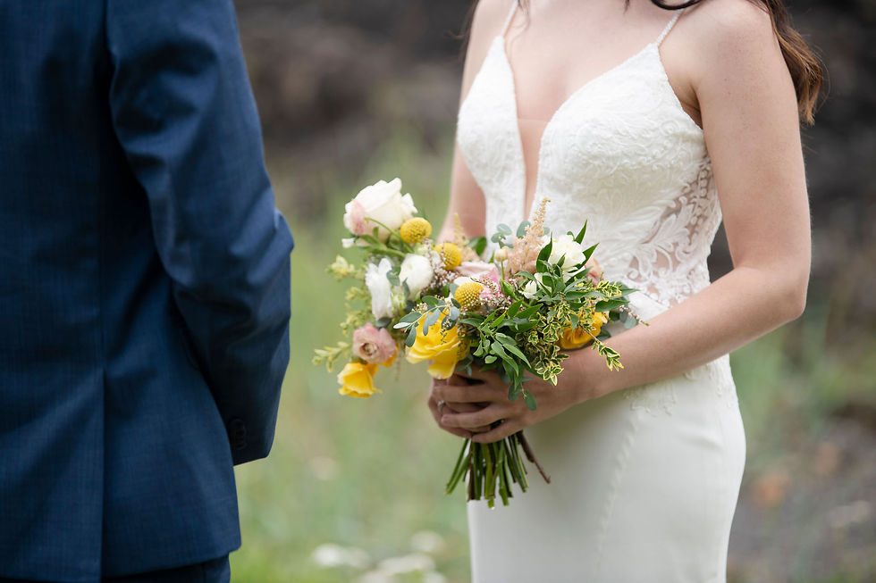 A bride holding a bright bouquet of flowers at her elopement in Ucluelet. Photographed by Ucluelet photographer Kaitlyn Shea.