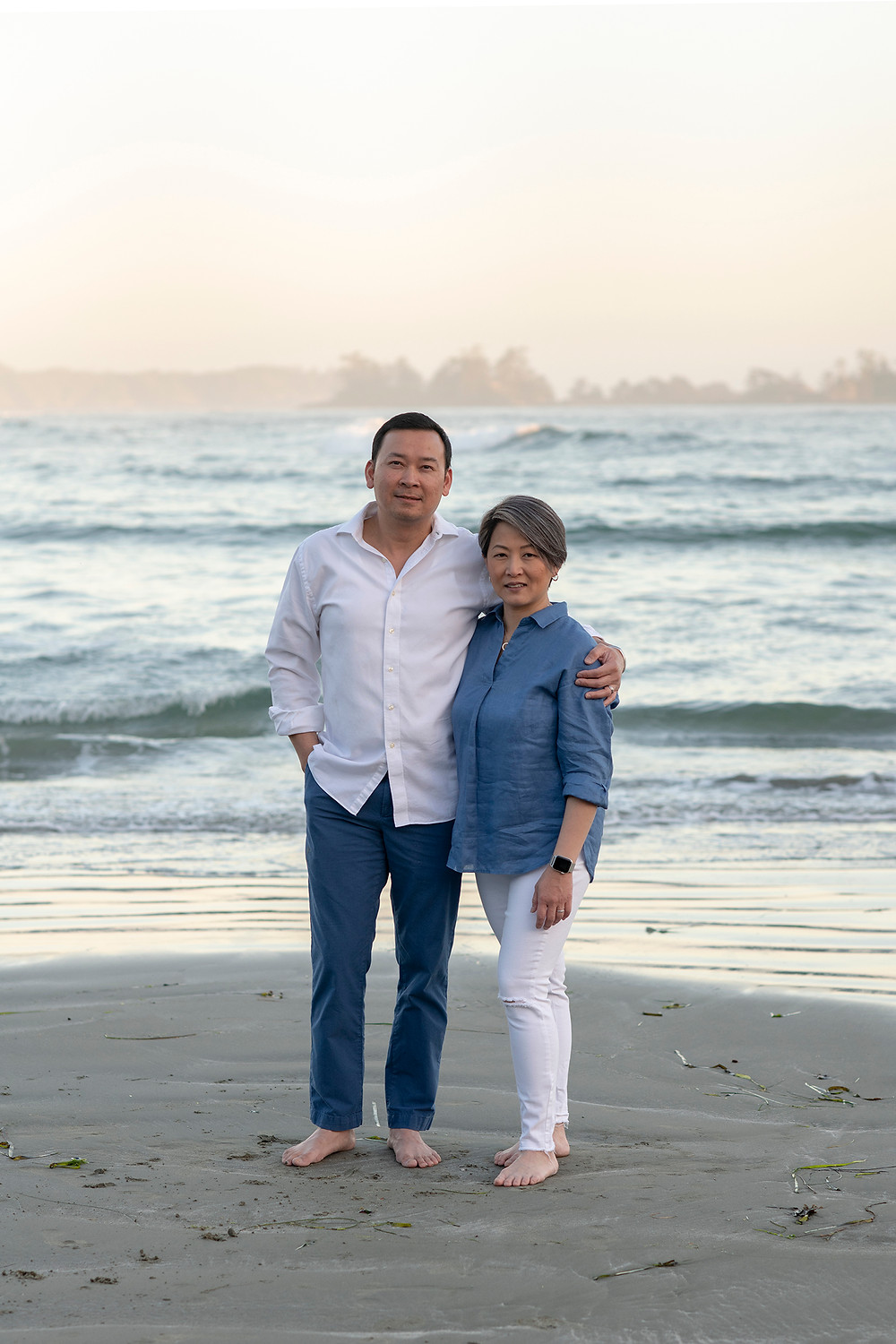 parents stand togther and smile for the camera during family pictures in Tofino | Photographed by Kaitlyn Shea